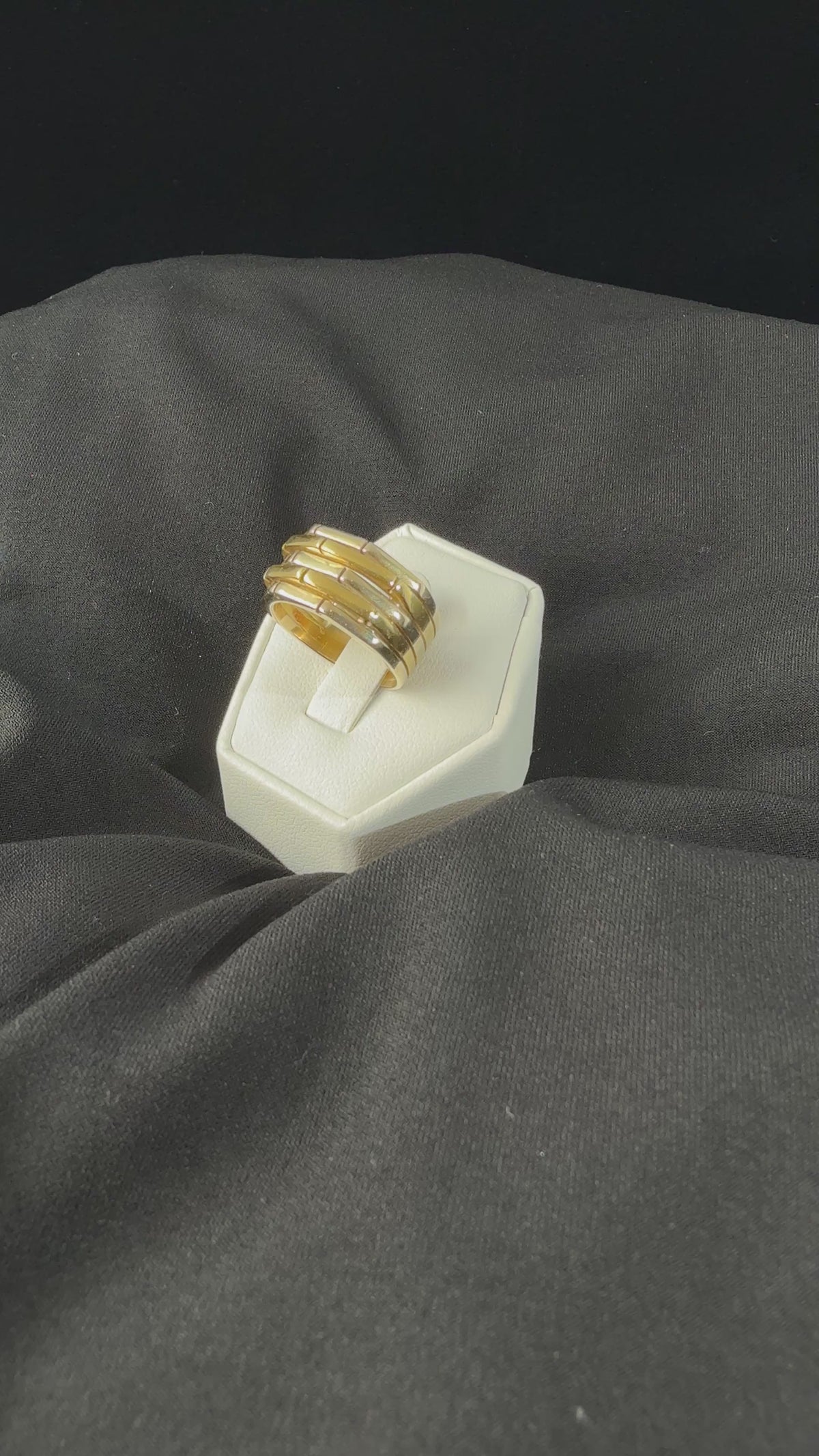 movie video of a heafty 18k yellow and white gold band ring with five raised alternating geometric segments